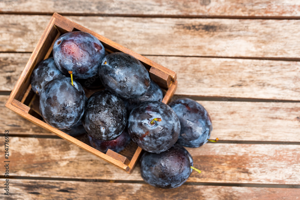 Fresh ripe plums in wooden box top view Fresh ripe plums in wooden box top view