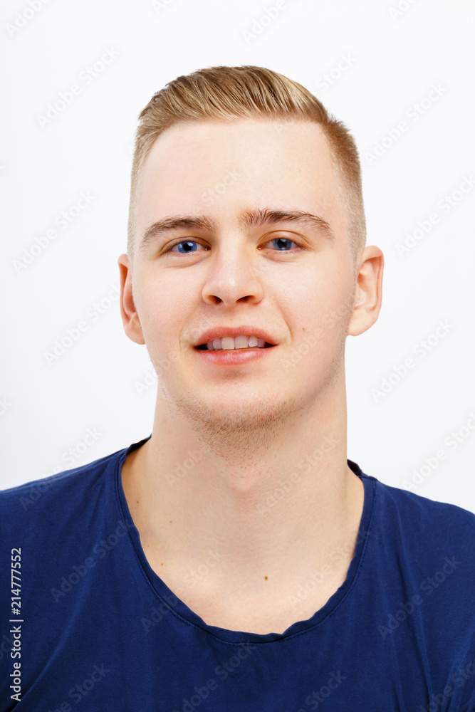 Young blond happy man in blue shirt smiles in studio, close up portrait Young blond happy man in blue shirt smiles in studio, close up portrait