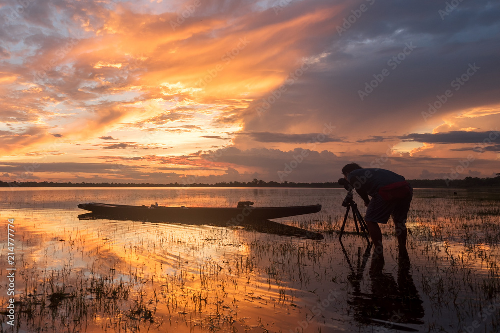 Φωτογραφία the photographer taking a picture of reflecion light of sunrise and fisherman bo