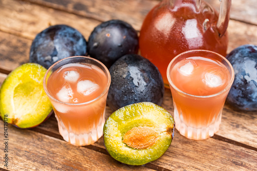 Plum brandy or slivovitz with fresh ripe plums photo