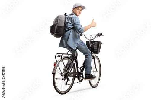 Teenager riding a bicycle and holding his thumb up