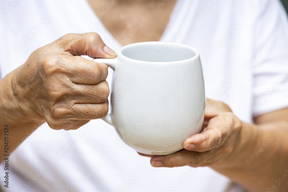 Senior woman's hand drinking coffee cup Senior woman's hand drinking coffee cup