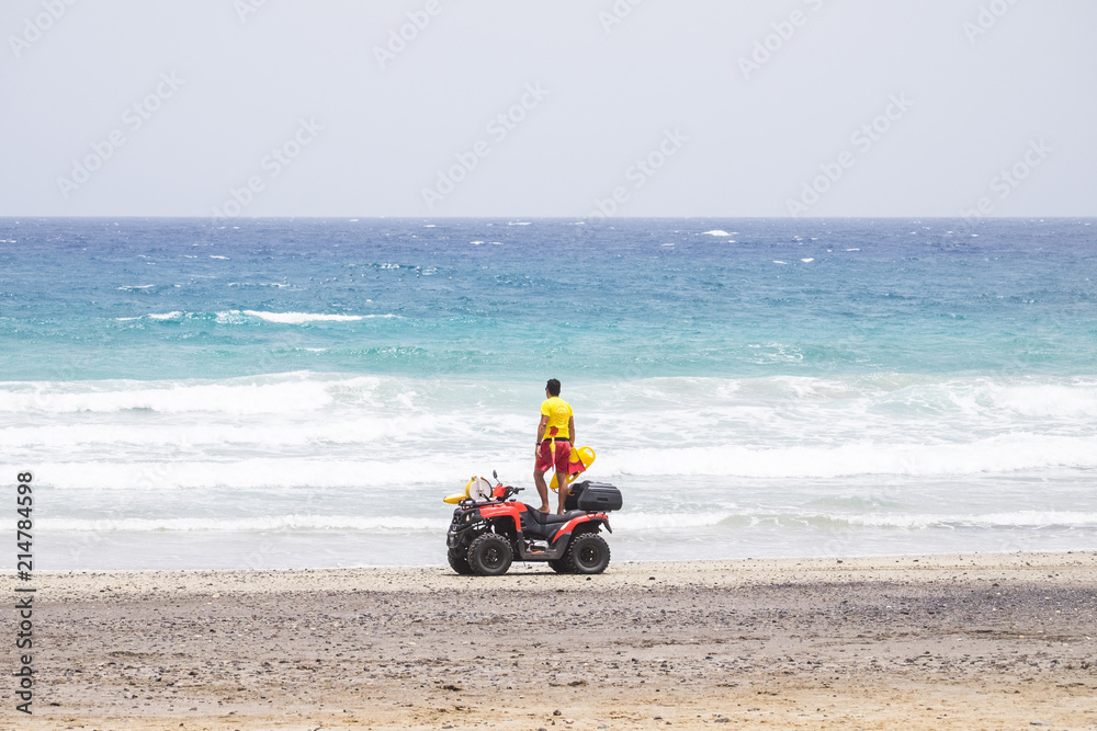 lifeguard on motorbike check and look on the ocean to verify the security of the beach. sand ocean vacation concept lifeguard on motorbike check and look on the ocean to verify the security of the beach. sand ocean vacation concept