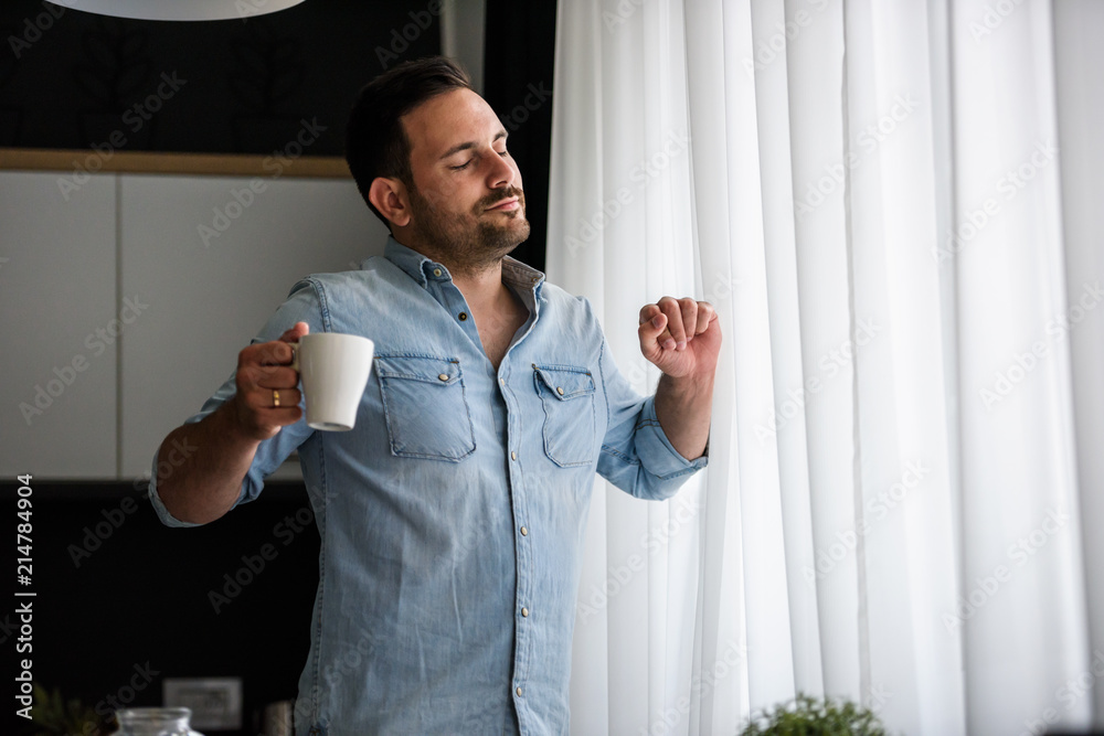 Tired man drinking coffee in the morning looking through window. Sleep  disorder Stock Photo | Adobe Stock