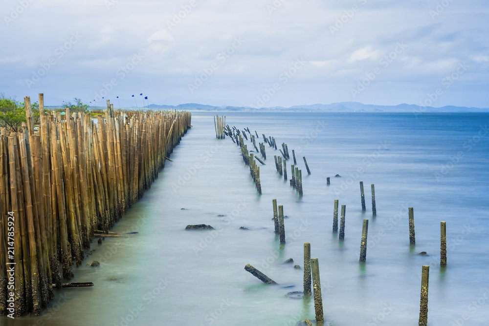 Long exposure seascape bamboo wall to protect the shore from the surf of the sea waves.Thailand. Long exposure seascape bamboo wall to protect the shore from the surf of the sea waves.Thailand.