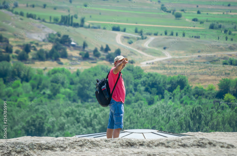 Tourists enjoy the sunny weather and walk around the ancient rock city in Uplistsikhe (Upliscyche), Georgia