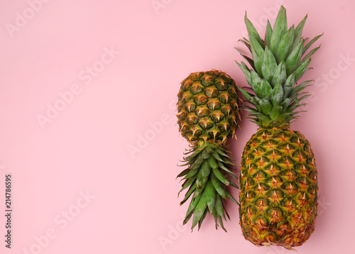 Delicious pineapples on color background