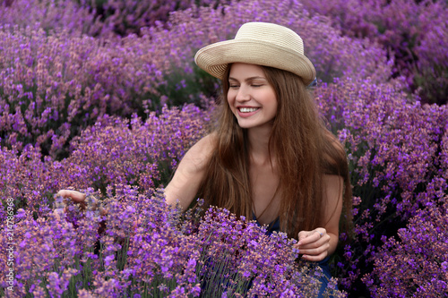 Beautiful young woman in lavender field on summer day