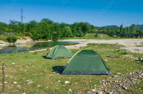The camping tents near mountain river in the summer 