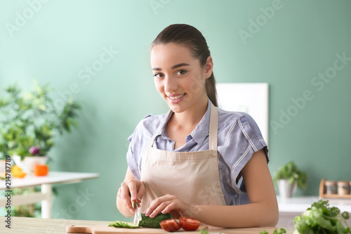 Young woman cutting vegetab...