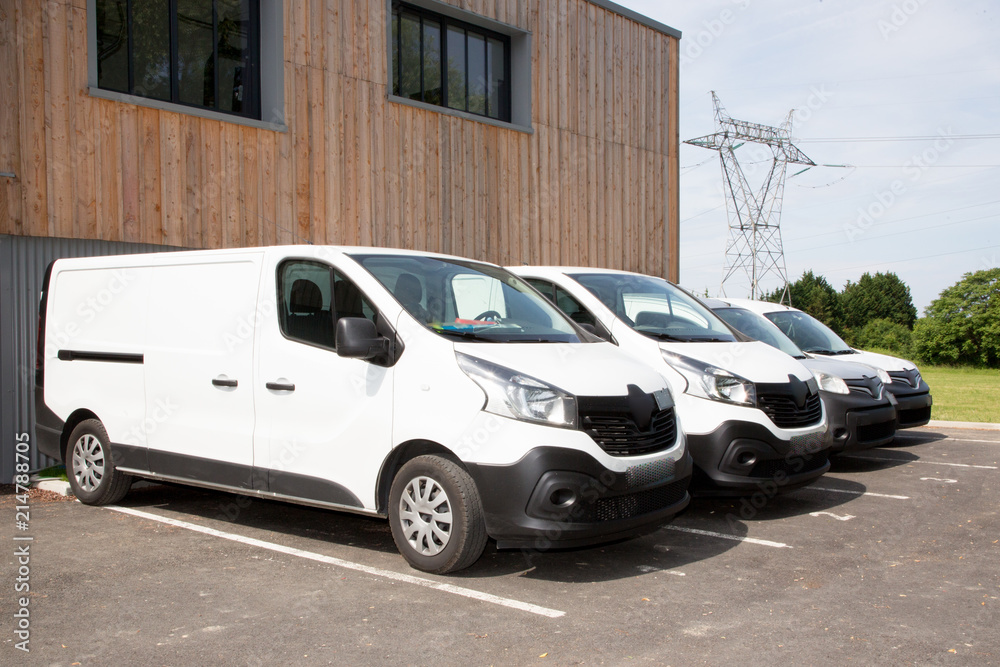 White commercial delivery vans in row to Warehouse Building