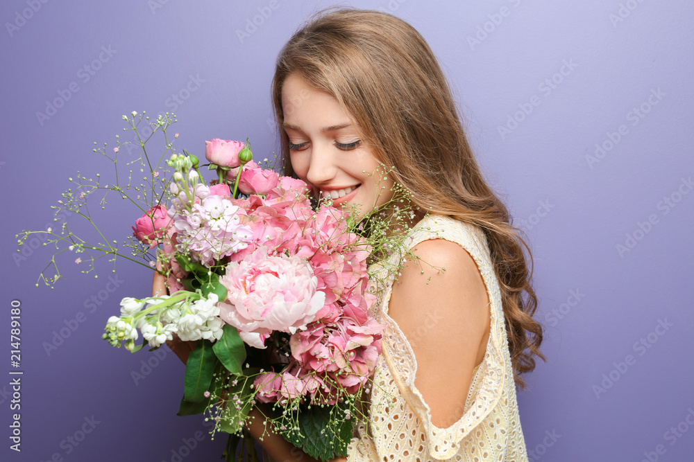 Young woman with beautiful flowers on color background