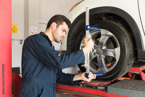 Принти на полотні Mechanic Checking Alignment Of Tire With Camber Caster Adapter