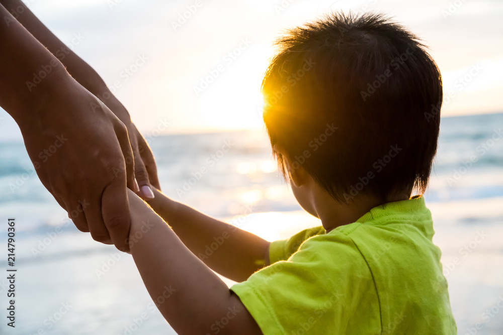 soft focus parent hold the little child hand during sunset, warm tone.