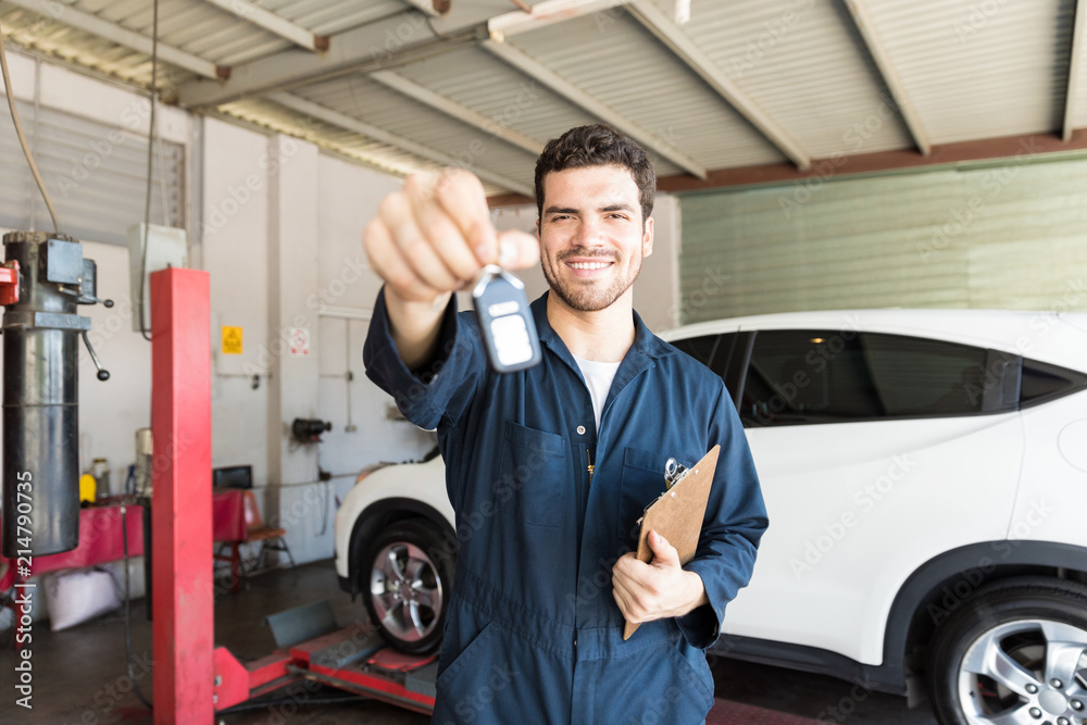 Smiling Mechanic Giving Car Key In Auto Repair Shop Smiling Mechanic Giving Car Key In Auto Repair Shop