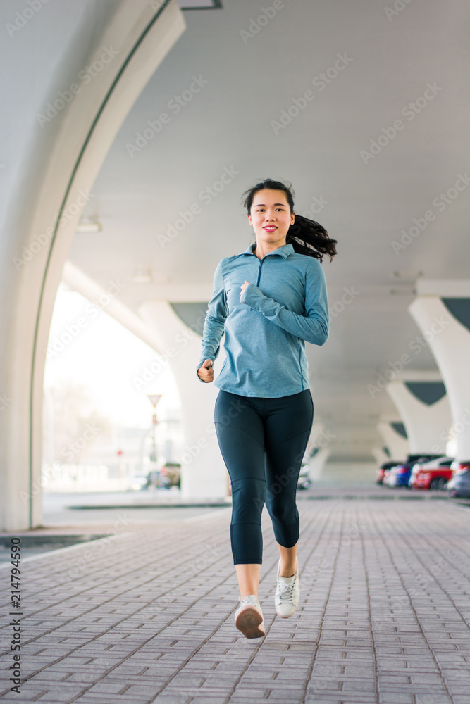 Girl running bellow the bridge in urban area Girl running bellow the bridge in urban area