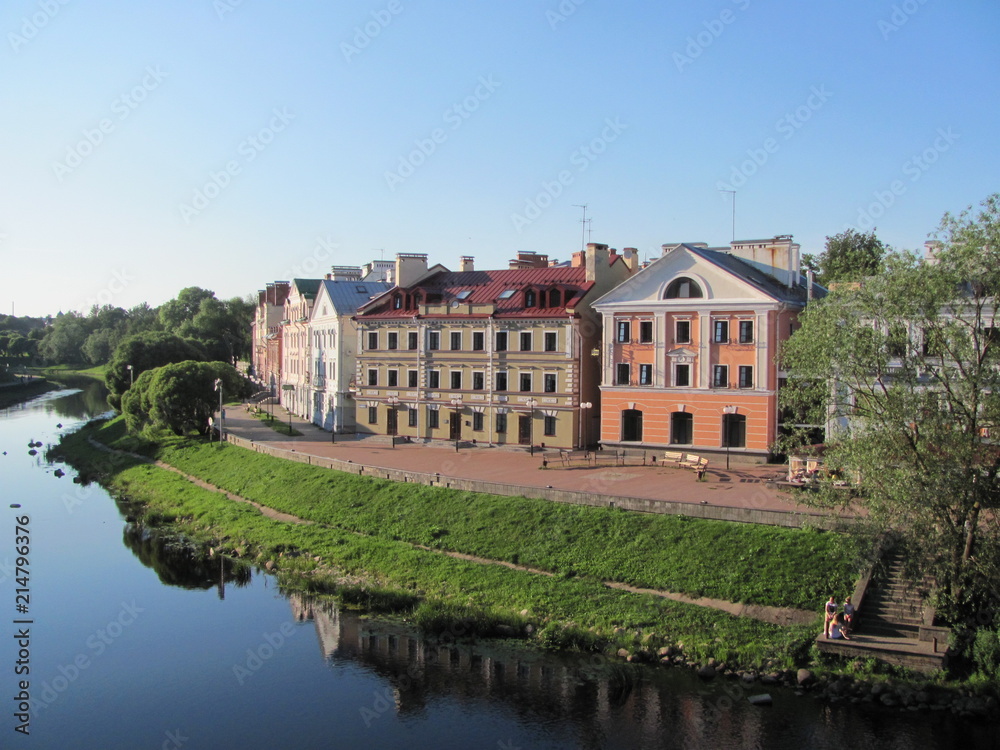 Beautiful embankment in Pskov, Russia, a row of beautiful houses and a river on a summer sunny day