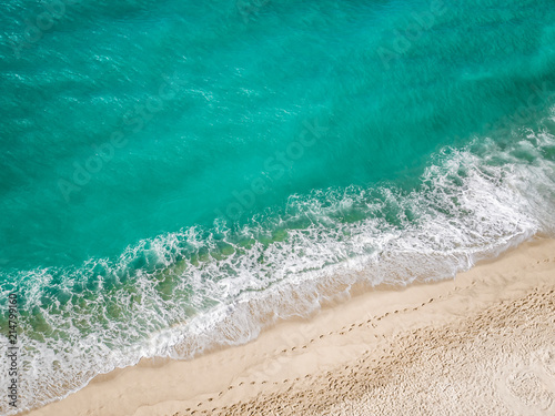 Above view of the turquoise mediterranean sea hitting the beach.