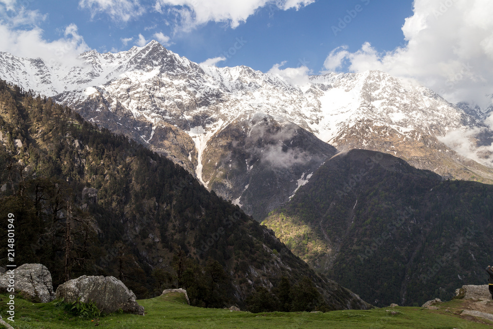Scenic Triund mountains covered by white snow with cloudy blue skies, McLeod Ganj, Snow Line, Himachal Pradesh, India.