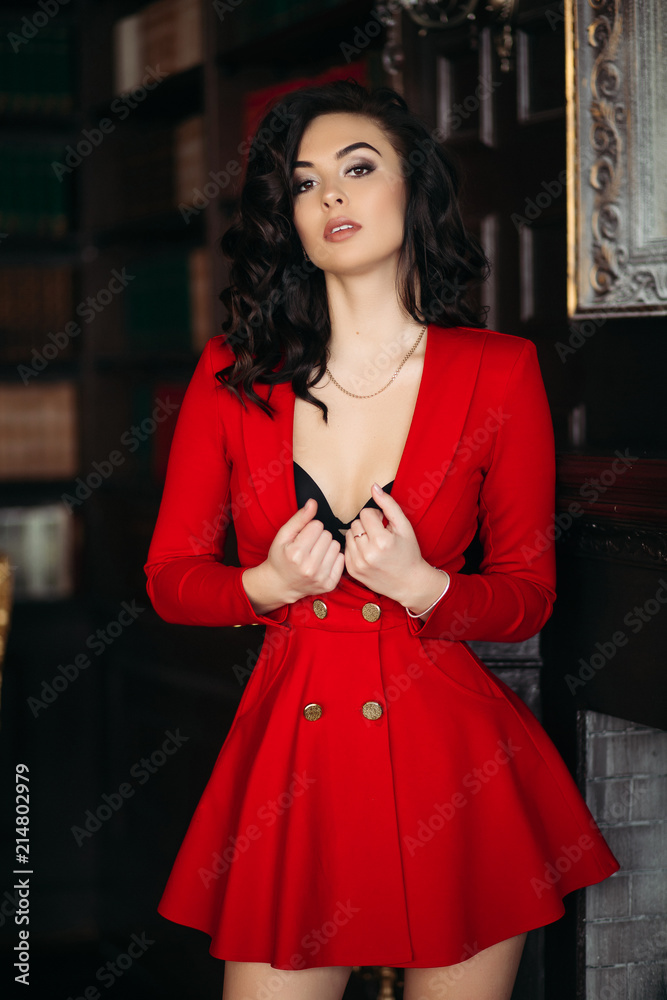 Sexy and hot girl in red dress undresiing, holding clothe in hand, and  touching hair. Woman with professional make up and volumed  hairstyleseductive touching her chest. Library interior. Stock Photo | Adobe