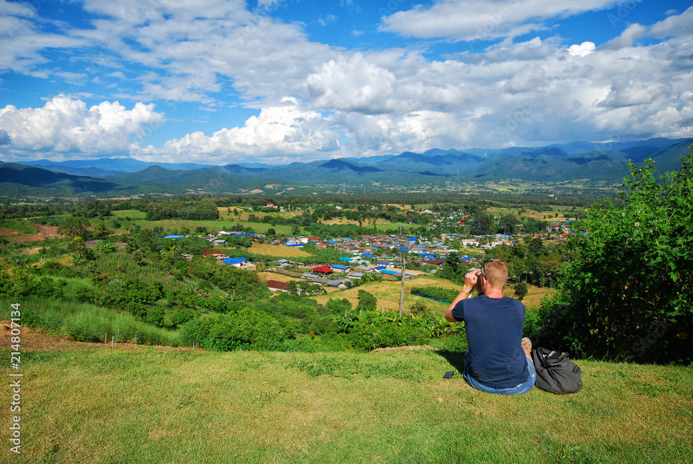 a man sit on the yard and seeing the view scenary landscape of Pai district in Mae Hong sorn, Thailand