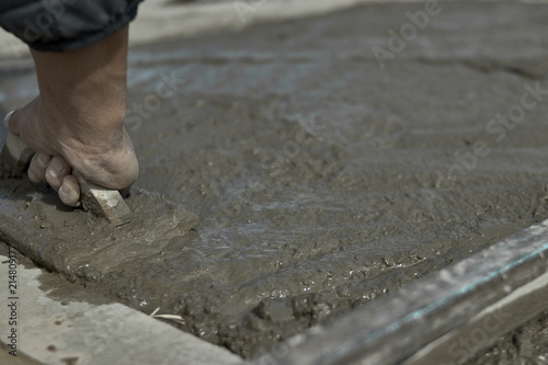 obrero trabajando con cemento fresco y llana
