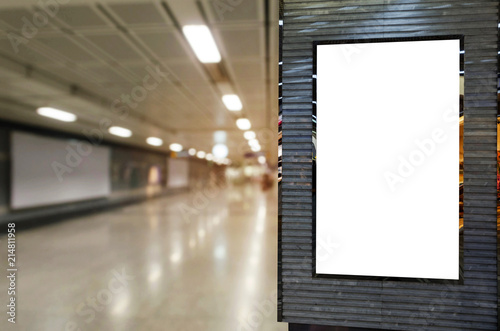 Fototapeta Naklejka Na Ścianę i Meble -  blank billboard or advertising light box for your text message or media content with blurred image of walkway in subway at railway station, transportation, commercial and marketing concept