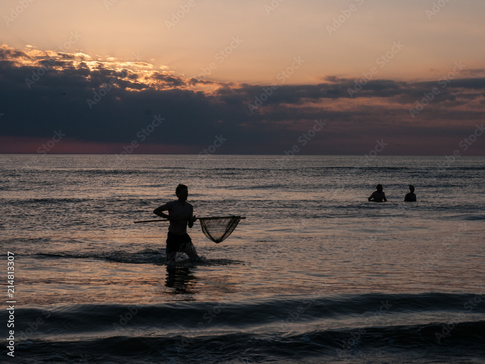 Fototapeta premium Krabbenfang bei Sonnenuntergang an der Nordsee
