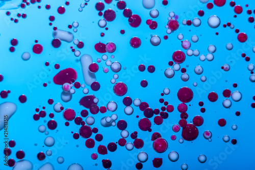 Red bubbles of blood cells on blue background closeup. Abstraction of medicine.