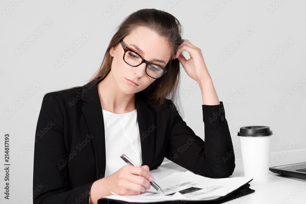 Businessman girl sitting at desk in office and working on laptop on white background. Businessman girl sitting at desk in office and working on laptop on white background.