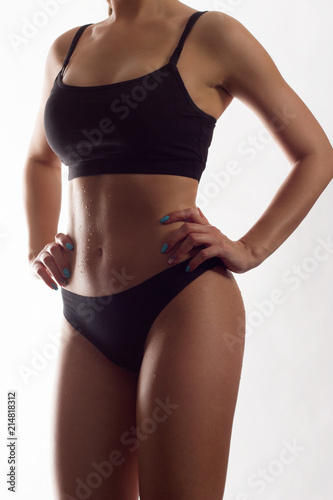 Slim body of the suntanned woman isolated on a white background. Black underwear. Sexual beautiful body. Healthy lifestyle, Diets.