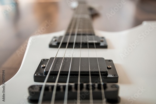 Weiße Heavy E-Gitarre auf braunem Hintergrund