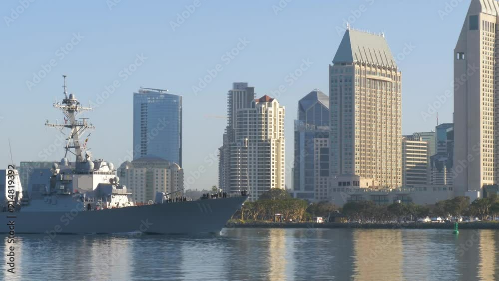 Warship sails against the background of San Diego's downtown in the morning at dawn.