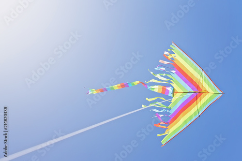 multi-colored kite flying on a blue sky background