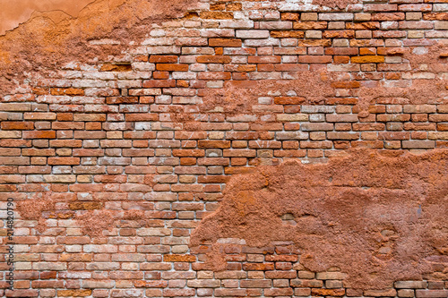 Old and damaged orange brown brick wall