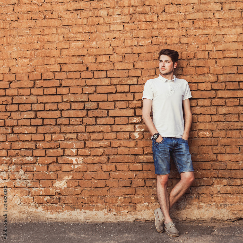 hipster young man on the brick wall hipster young man on the brick wall
