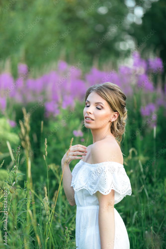 Beautiful young happy girl in the blossoming fields, thinking about her life and goals. Slow life, minimalism, mindfulness Beautiful young happy girl in the blossoming fields, thinking about her life and goals. Slow life, minimalism, mindfulness