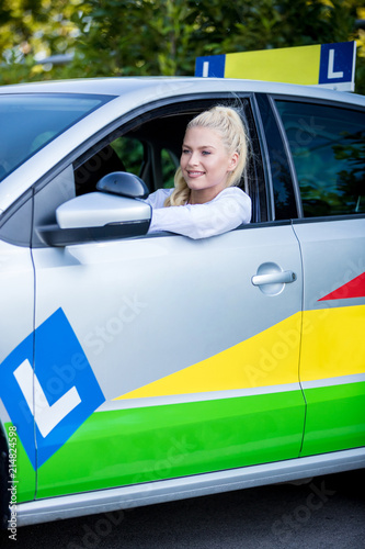 Smiling driving student sitting in a car