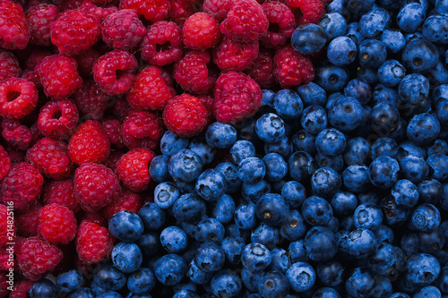 Blueberries and raspberries background. Top view.