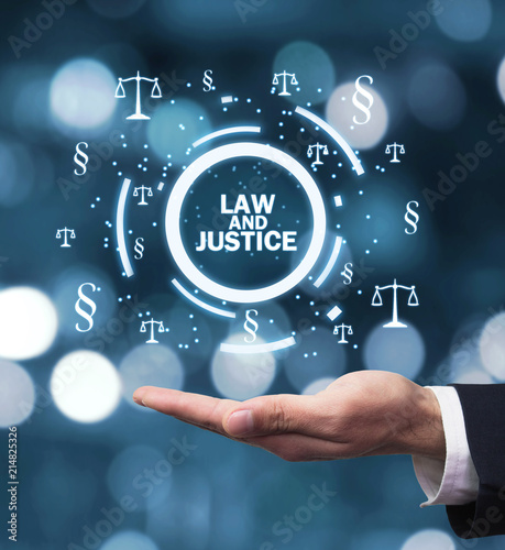 Hand holding Justice Scales and Paragraph symbols. Law and Justice concept