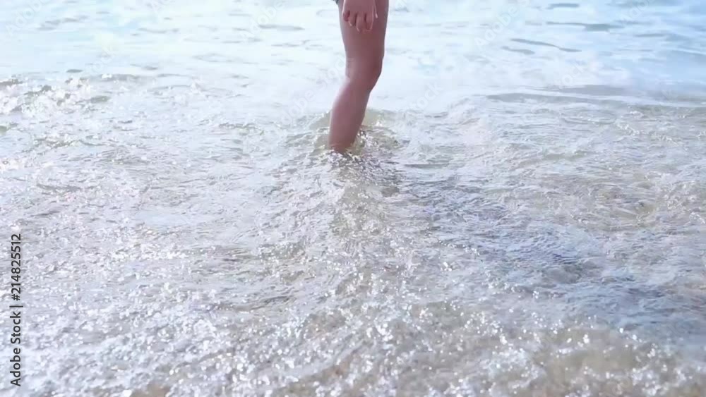 Happy barefoot child have fun on beach walk. Girl run along sea surf by water pool and jump with splashes. Summer vacation with kids on tropical island Happy barefoot child have fun on beach walk. Girl run along sea surf by water pool and jump with splashes. Summer vacation with kids on tropical island