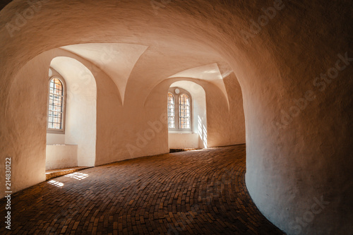 Inside round tower in copenhagen warm light falling through tower windows
