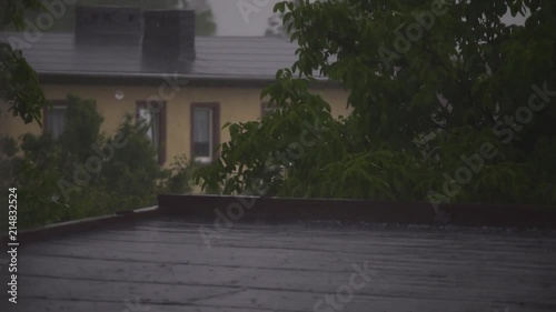 Heavy rain falling on the rofftop of a building photo