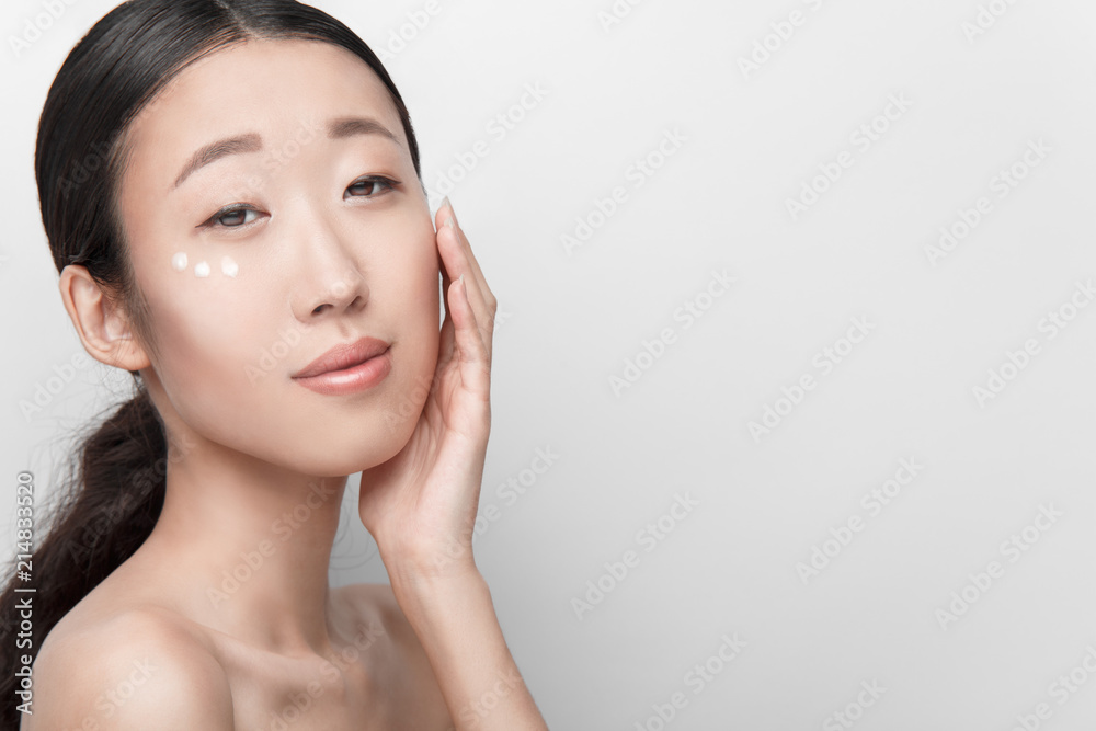 1000px x 667px - Close up beauty portrait of beautiful asian half naked woman applying face  cream isolated on white background Stock Photo | Adobe Stock