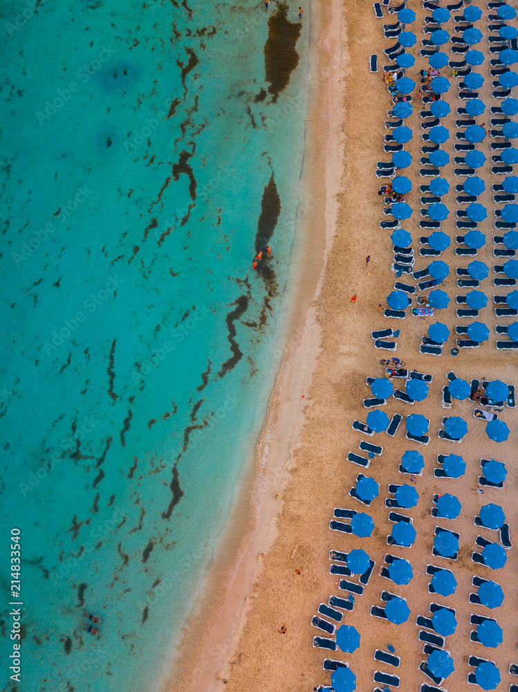 Makronissos beach from above - Light blue warm water, golden sand and blue umbrellas under the sun