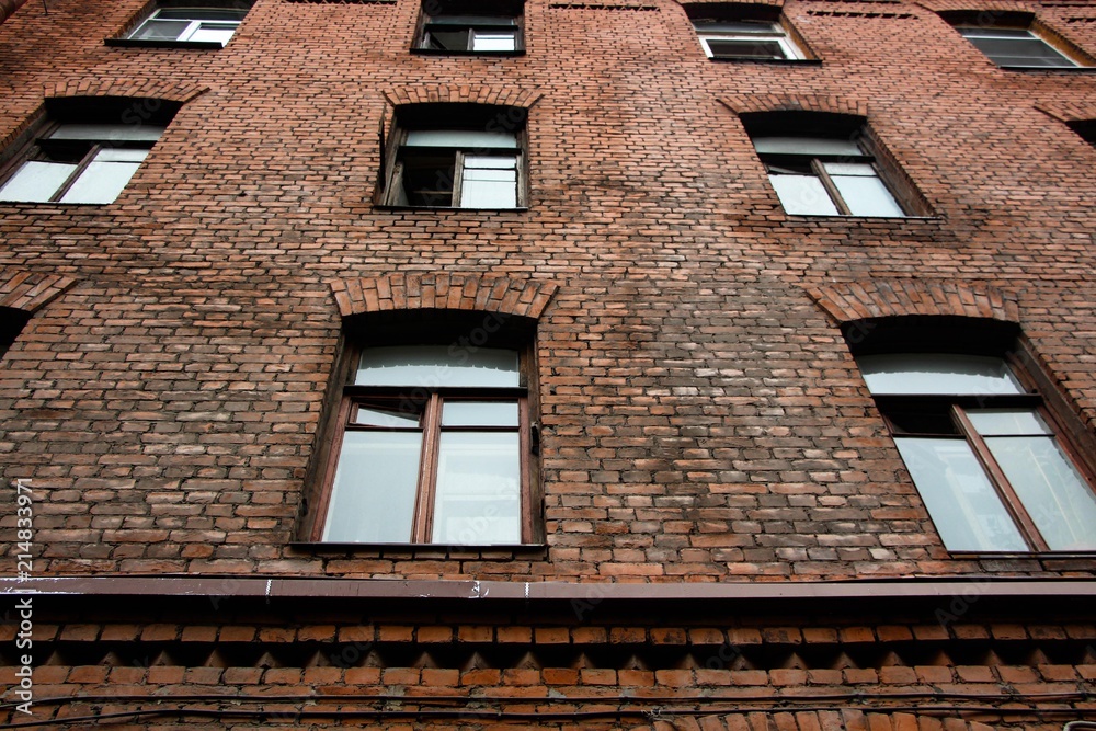 Obraz premium Large windows in an old brick building. The building was built in the nineteenth century, it was in these houses that the loft style originated.