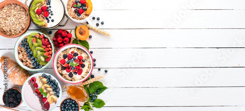 Wallpaper Mural Large Assortment of porridge with fruit and berries. Breakfast. On a white wooden background. Top view. Free space for text. Torontodigital.ca