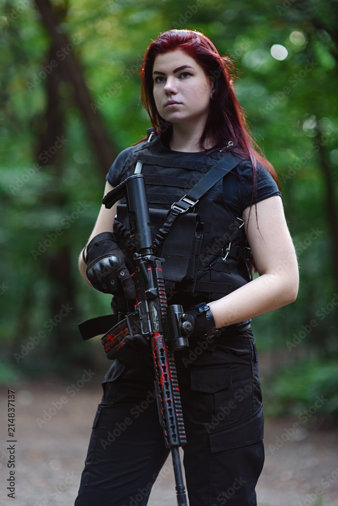 Portrait of girl with red hair and rifle