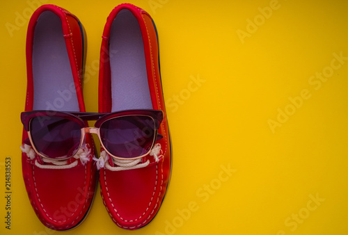 red moccasins with glasses on a yellow background