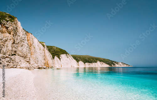Fteri beach in Kefalonia Island, Greece. One of the most beautiful untouched pebble beach with pure azure emerald sea water surrounded by high white rocky cliffs of Kefalonia photo